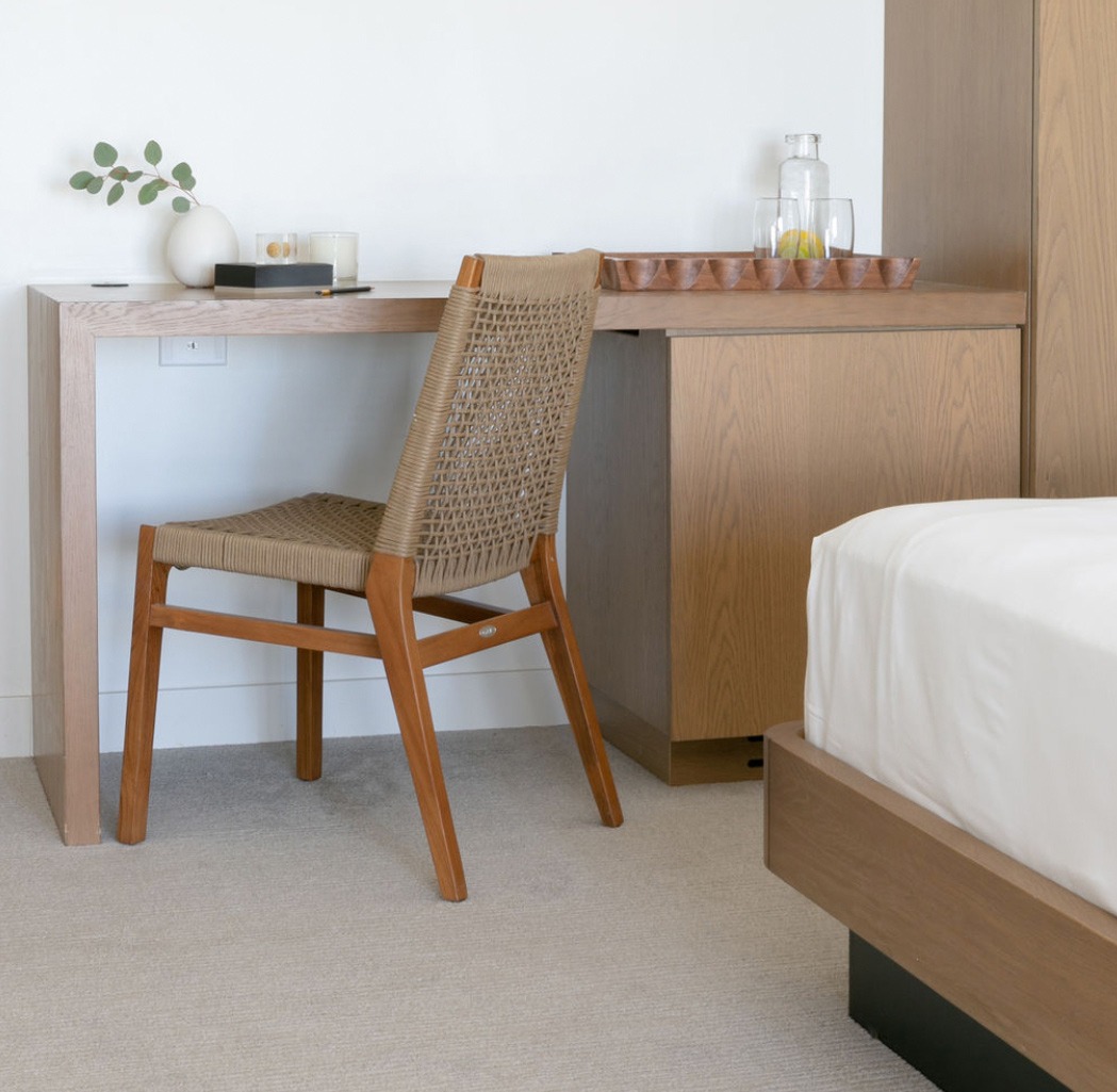 A hotel room with a desk, chair, and bed